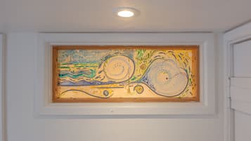 A painting in a recessed wall niche with a ceiling light above.