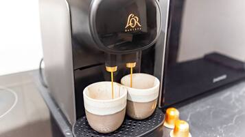 A coffee machine with two cups on its drip tray.