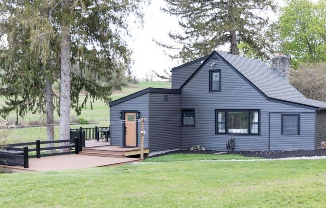 A two-story building with a sloped roof and a small porch.