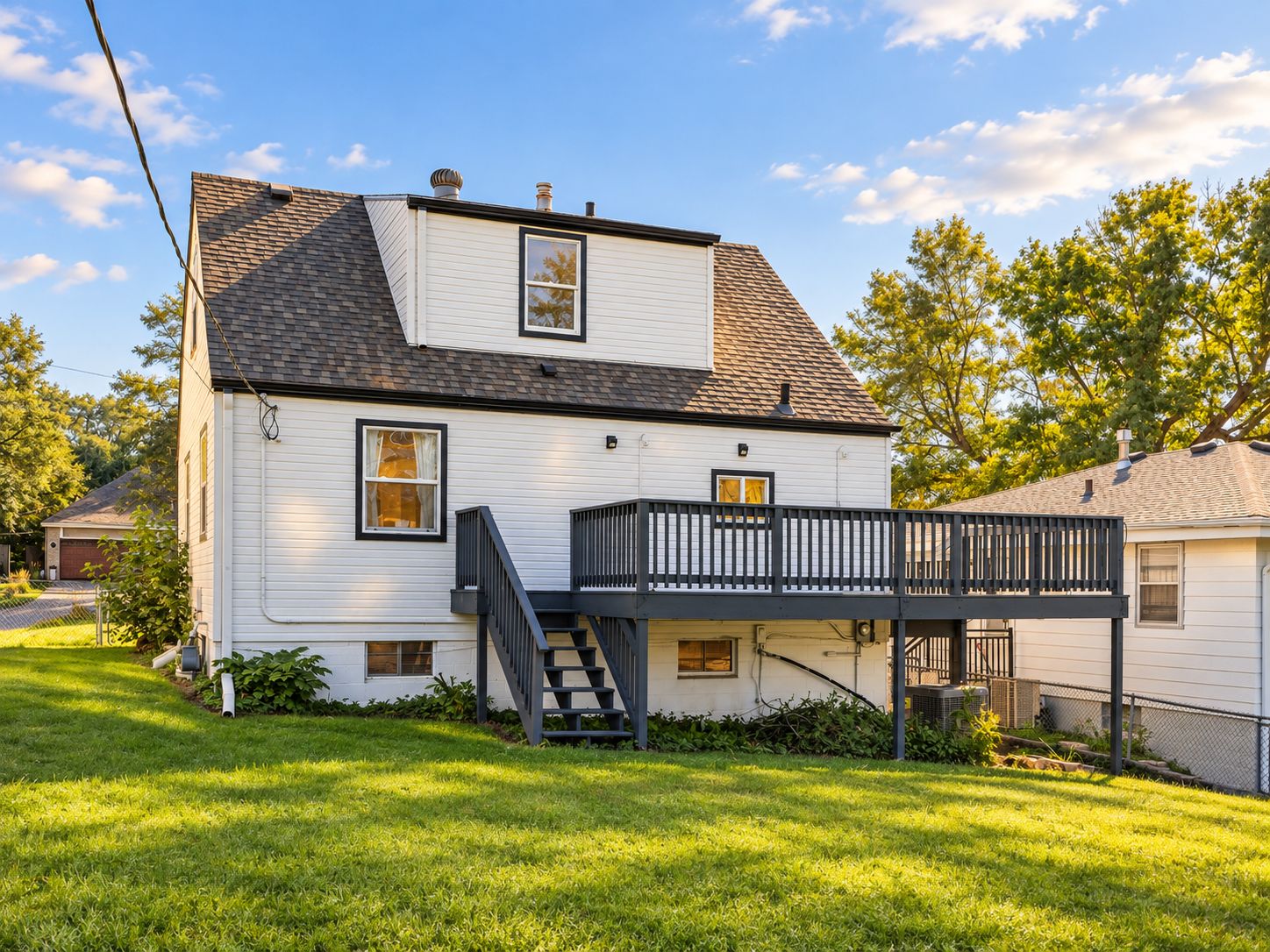 A two-story house with a front porch and a small staircase leading to the second floor.