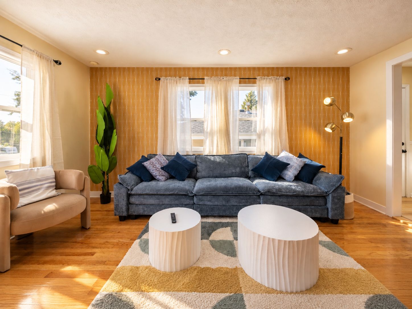 A modern living room with a grey sofa, a beige armchair, and a round coffee table.