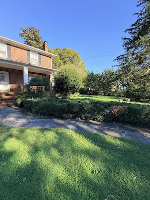 A residential property with a brick facade, a well-maintained lawn, and a clear blue sky. - Cozy Home in Serene Orange walking distance to town! (Orange)