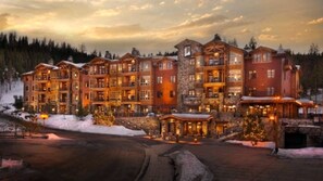 Ein mehrstöckiges Hotel mit Innenhof, Steinfassade und zahlreichen Balkonen.