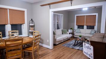 Una sala de estar con una mesa de comedor, sillas, un sofá y una mesa de centro.