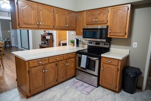 Une cuisine avec des meubles en bois, une cuisinière en acier inoxydable et un four à micro-ondes.