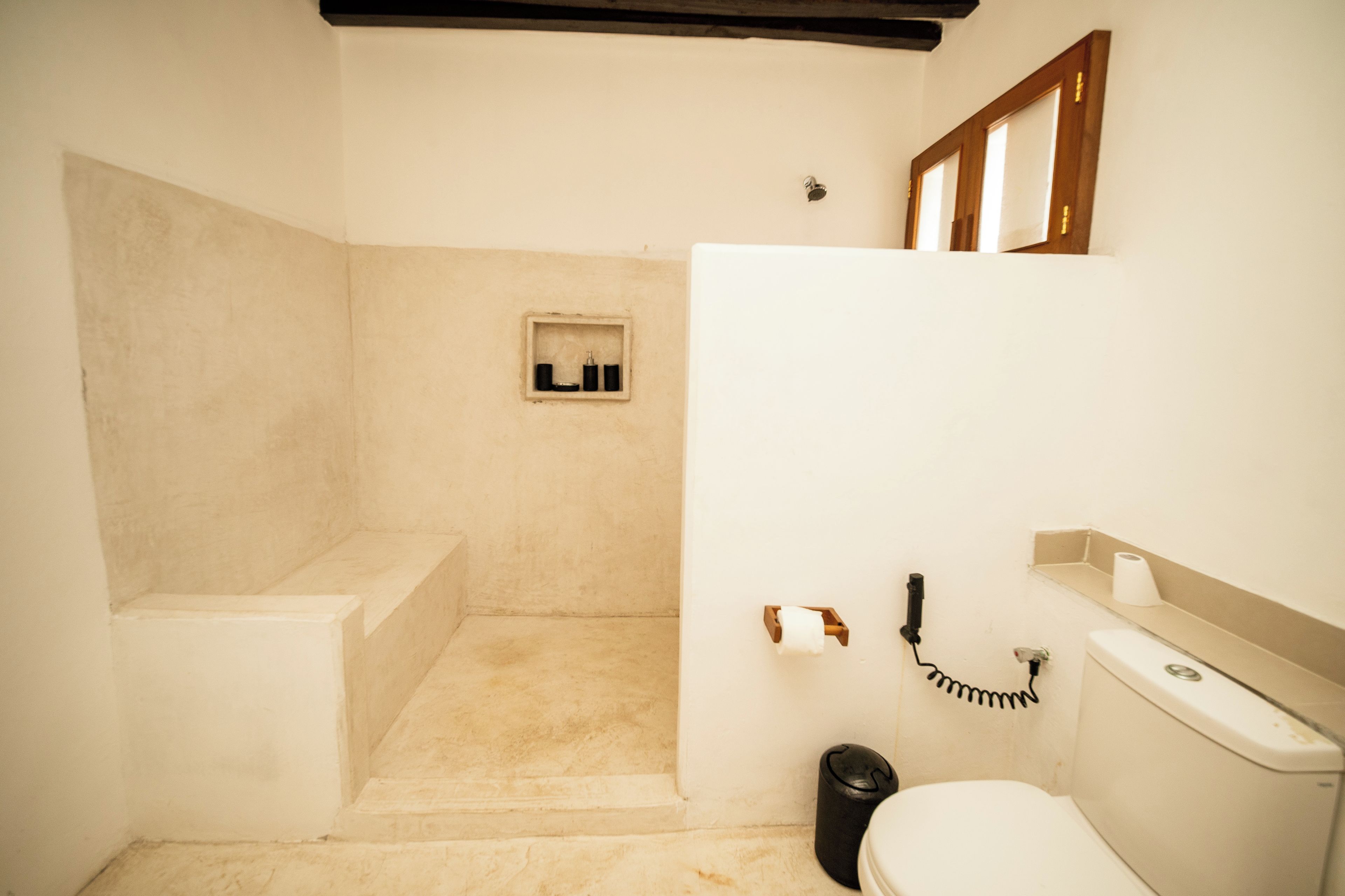 A bathroom with a toilet, sink, and shower area.