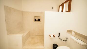 A bathroom with a toilet, sink, and shower area.