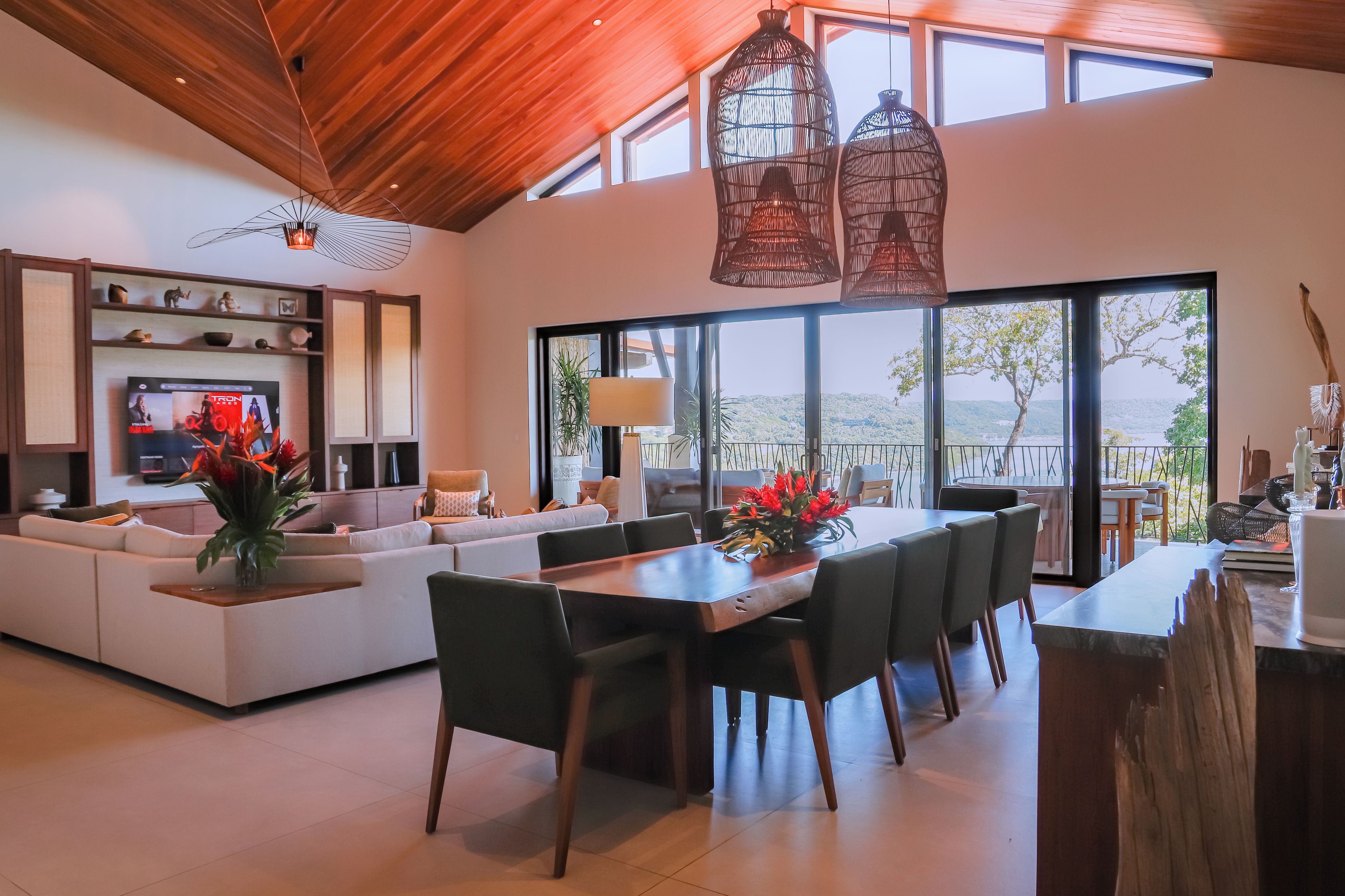 A modern living space with a dining area, large windows, and a view of the outdoors.