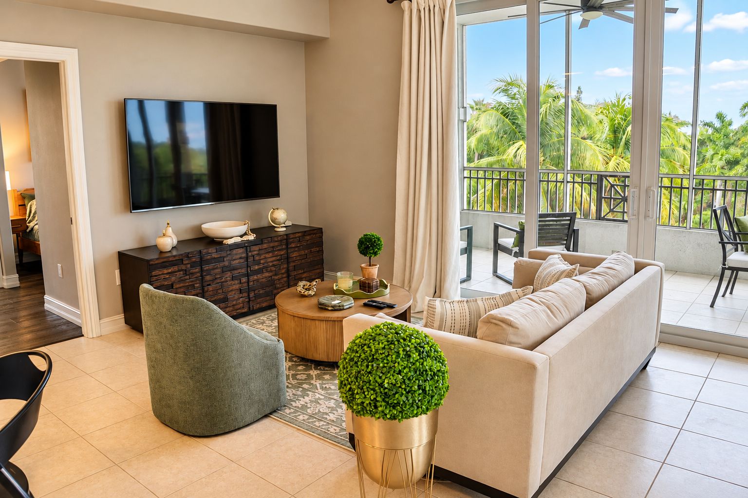 A modern living room with a sofa, armchair, coffee table, and a flat-screen TV.