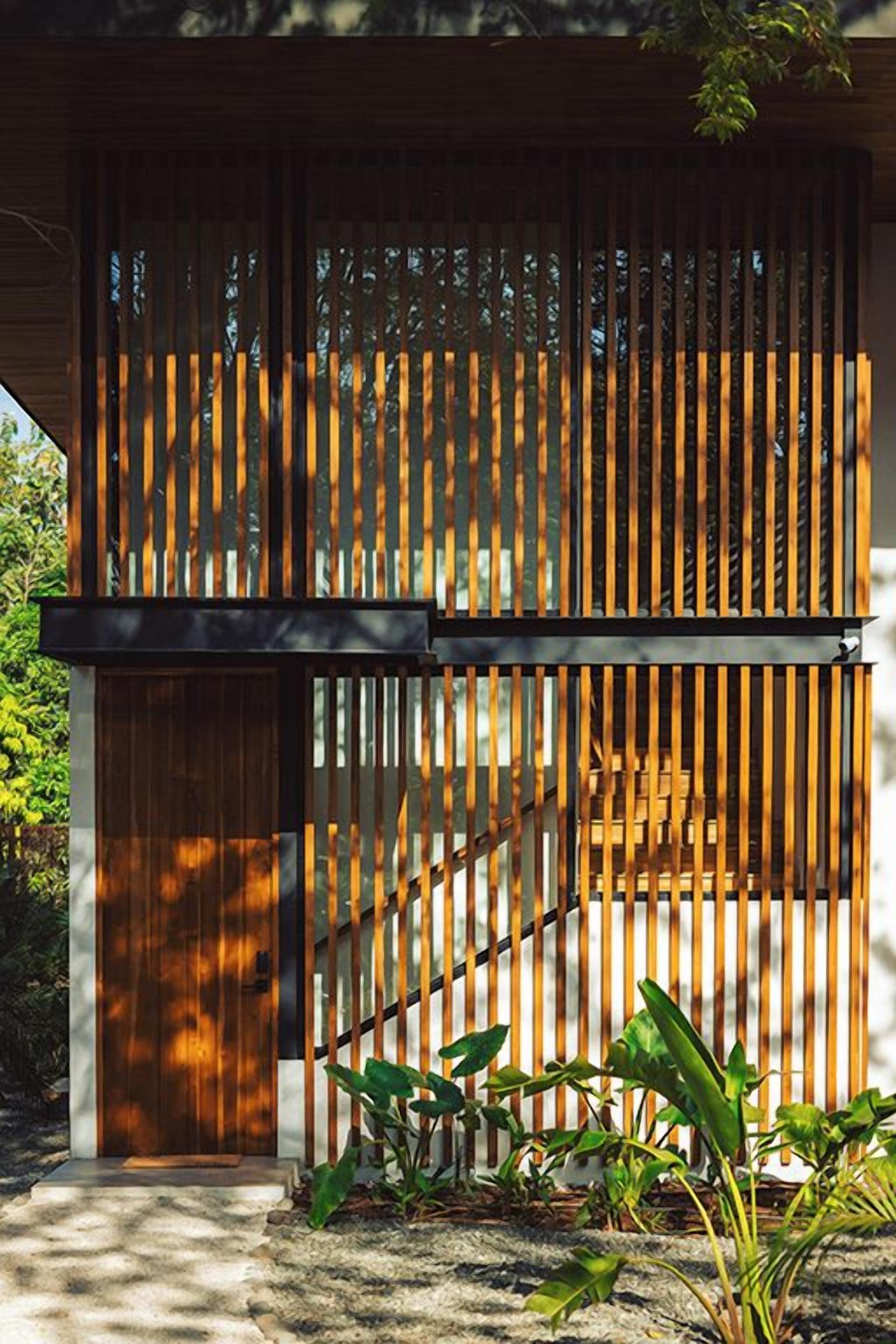 A wooden staircase leading to a door with a metal railing.