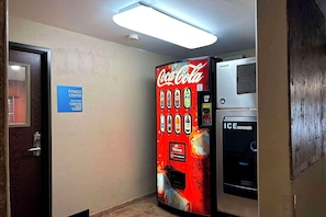 A Coca-Cola vending machine and an ice dispenser in a hallway. - Express Inn Leesville Fort Polk (Leesville)