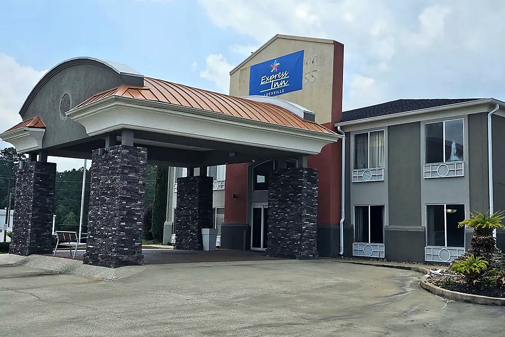 A hotel with a covered entrance, stone pillars, and a sign for Express Inn.