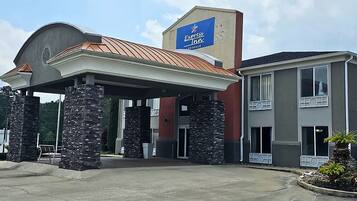 A hotel with a covered entrance, stone pillars, and a sign for Express Inn.