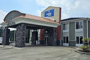Un hotel con entrada techada, pilares de piedra y un letrero que dice Express Inn.