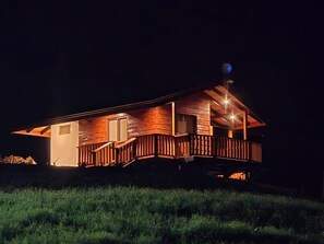 Puinen mökki, jossa on kuisti ja satelliittiantenni.