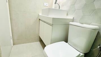Ein Badezimmer mit Toilette, Waschbecken und Spiegel.