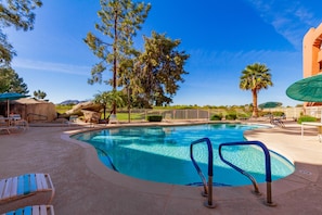 A swimming pool with lounge chairs and umbrellas, surrounded by trees and a clear sky. - CASA AERIE- Amazing Pool View 3rd floor (Phoenix)