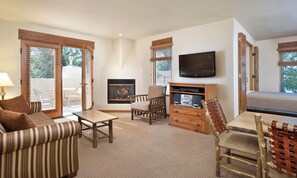 A living room with a fireplace, a television, and a sofa. - Tasteful apartment, 2 bedrooms, cosy,warm, inviting (Taos)