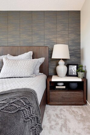A bedroom with a bed, a nightstand, a lamp, a framed photo, and a small plant. - Private 1 bed room with free parking on premises (Calgary)