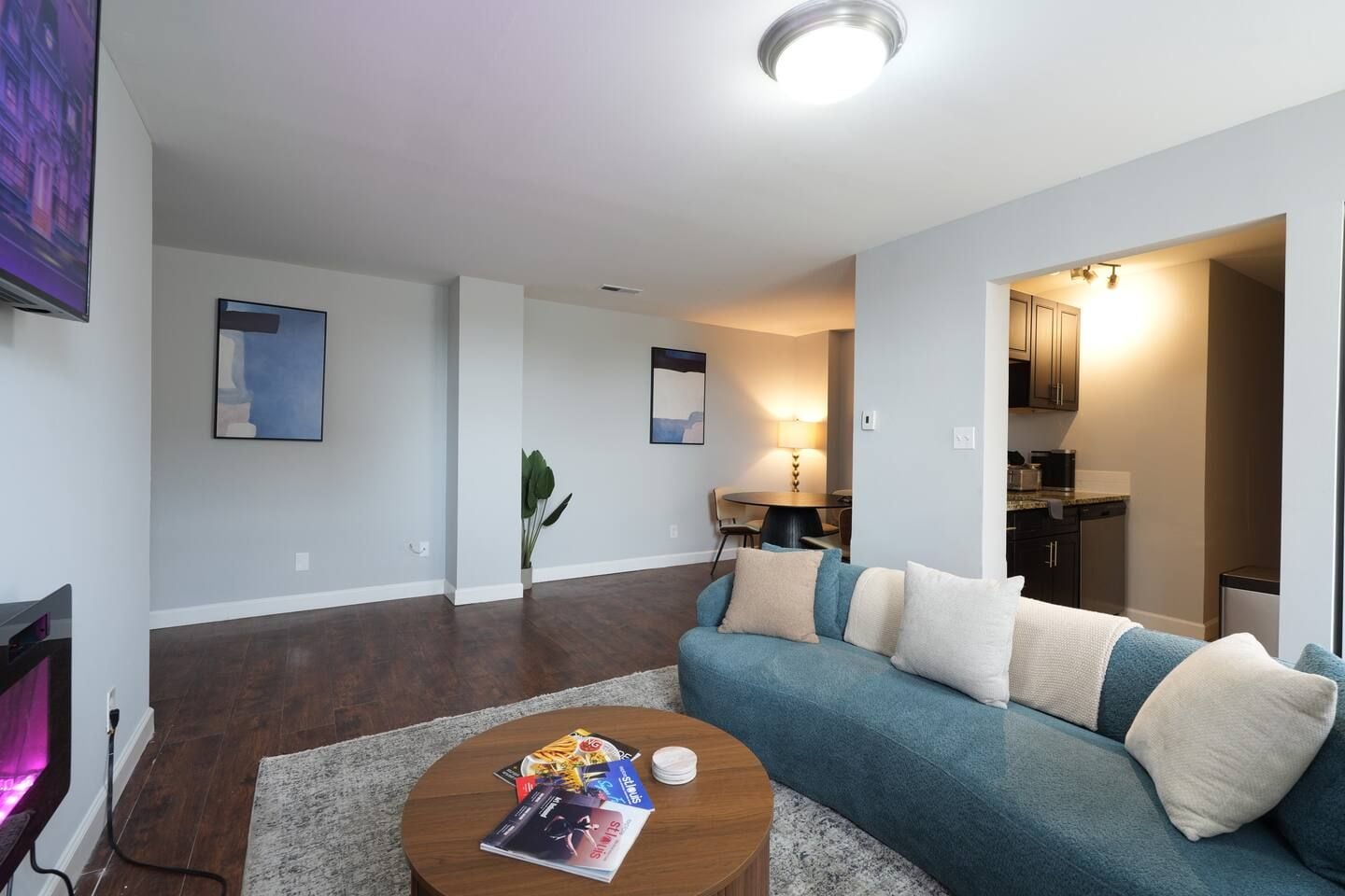 Un salon moderne avec un canapé, une table basse et un coin repas à l’arrière-plan.