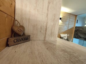 Eine Holzwand mit einem Schild, auf dem 'CHAMBRE' steht, und einer herzförmigen Dekoration.