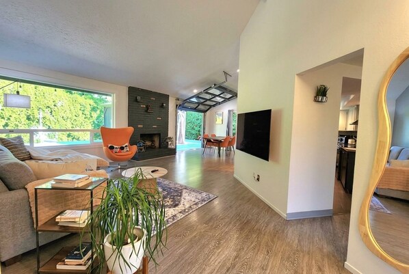 A modern living room with a sofa, a coffee table, and a TV mounted on the wall. - The Warm Timber Retreat (Vancouver)