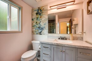 A modern bathroom with a toilet, vanity, and a large mirror. - The Warm Timber Retreat (Vancouver)