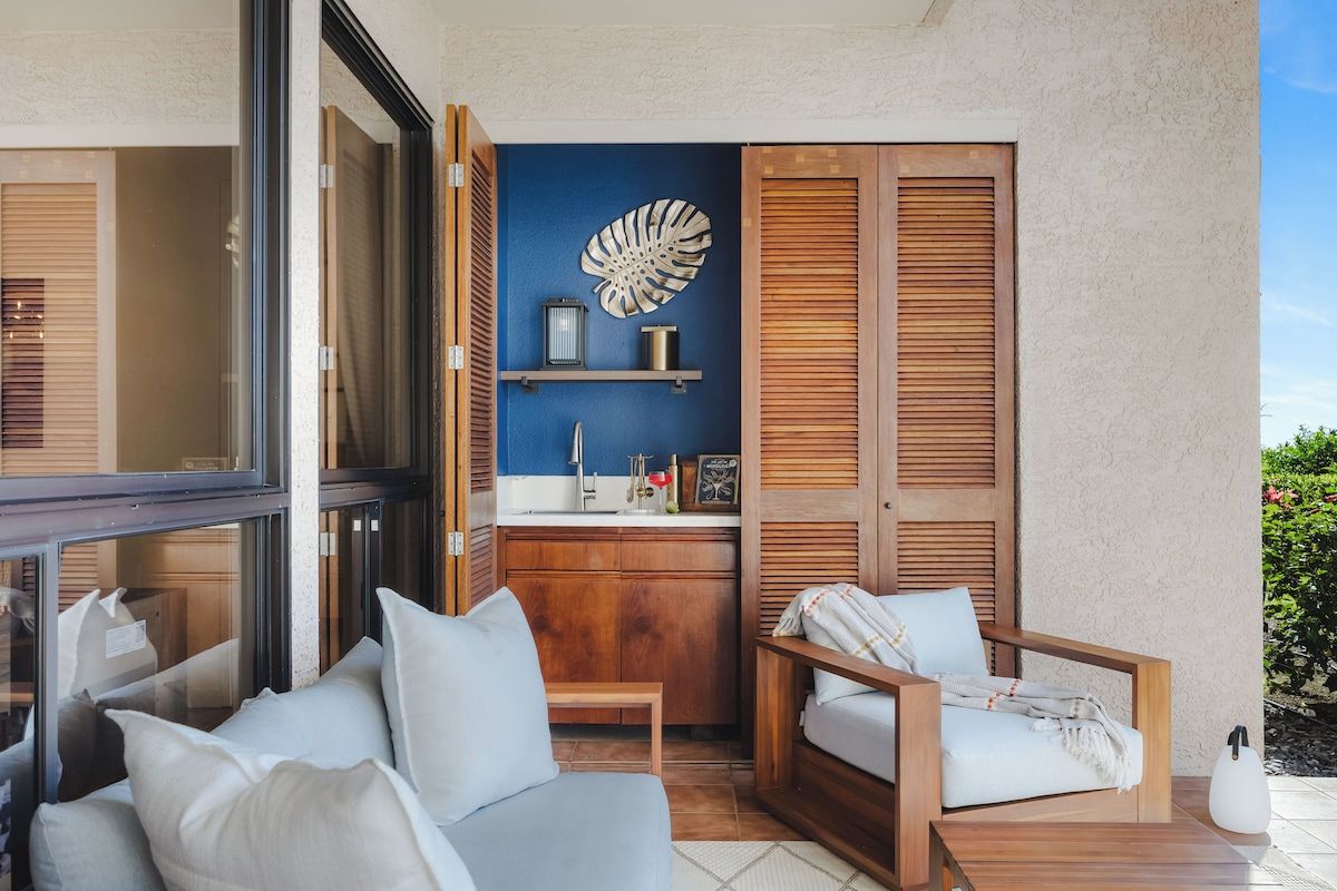 Un espacio habitable pequeño con kitchenette, un sofá, una silla y un adorno decorativo en forma de concha.