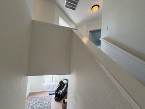 Eine Treppe führt zu einer zweiten Etage mit einem Massagesessel und einer blauen Matte auf dem Boden.