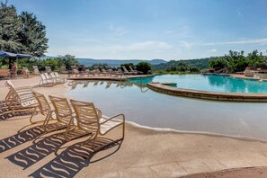 A pool with lounge chairs and a clear view of the mountains in the background. - Hilltop Lake Views | Hollows Resort Amenities (Jonestown)