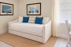 A bedroom with a bed, a chair, a window with blinds, and two framed pictures on the wall. - Coastal Marsh-View Retreat with 3BR/3BA + Office & Near Historic Downtown (St. Augustine)