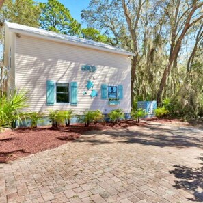 A single-story building with a brick driveway, surrounded by trees and shrubs. - Coastal Marsh-View Retreat with 3BR/3BA + Office & Near Historic Downtown (St. Augustine)