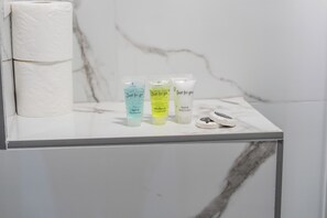 A bathroom counter with three toiletry bottles labeled 'Just for you' and a roll of toilet paper. - Sutherland Apartments - Apt 33 (London)
