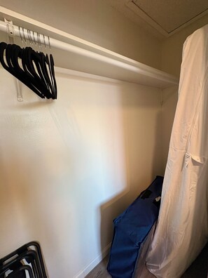 A corner of a room with a white wall, a hanging rack with black items, a blue object, and a white curtain. - 5 minutes to the beach! The Hideaway on Lillie Ave. (Summerland)