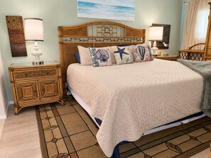 Een slaapkamer met een bed, nachtkastjes en een decoratief hoofdeinde.