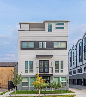 A modern two-story building with a flat roof, large windows, and a small front porch. - 3BR Townhome Near Bishop Arts |Rooftop & Game Room (Dallas)