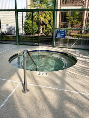 Ein Whirlpool mit Metallleiter und einem Schild, das eine Wassertiefe von rund 90 Zentimetern angibt.