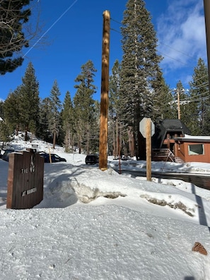 A wooden signpost with a cabin in the background. - Treehouse • Across from the Village. Walkable to Gondola & Ski‑Back Trail. (Mammoth Lakes)