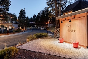 A property named 'Tree House' with a gravel driveway, wooden fence, and a street view. - `Treehouse` 2 Bd Cozy Unique Home Steps to Village (Mammoth Lakes)