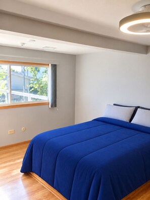 Quarto com cama, janela e luminária no teto.