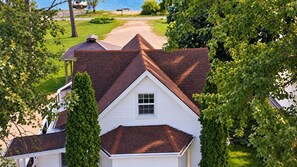 Une maison d’habitation avec un toit en pente, une petite fenêtre et une pelouse bien entretenue.