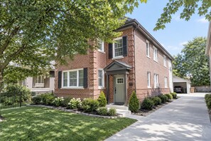 A two-story brick house with a front porch, a garage, and a well-maintained lawn. - 714 Rockford apartment (Rockford)