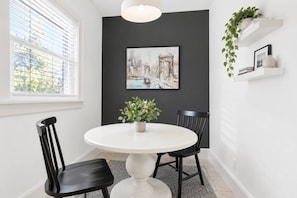A dining area with a round table, two chairs, a potted plant, and a framed picture on the wall. - 714 Rockford apartment (Rockford)