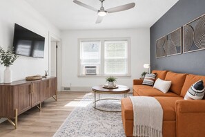 A modern living room with a sofa, a coffee table, and a TV mounted on the wall. - 714 Rockford apartment (Rockford)