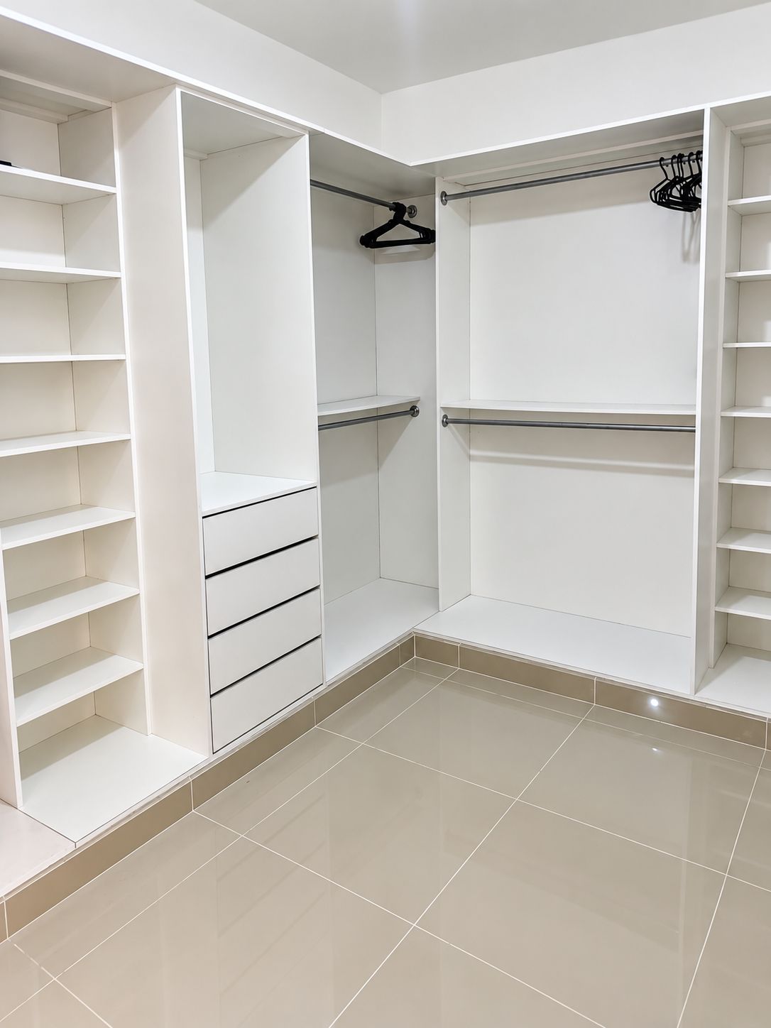 A walk-in closet with open shelving, a hanging rod, and a mirrored closet door.