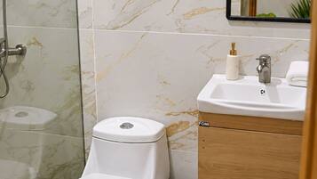 Une salle de bain moderne équipée de toilettes, d’un bidet et d’un lavabo avec un miroir au-dessus.