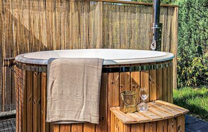 Een hottub met een handdoek en twee glazen op een houten terras.