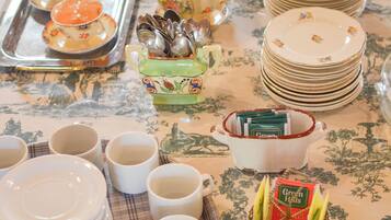 A table set with various dishes, cups, and a teapot, indicating a dining arrangement.