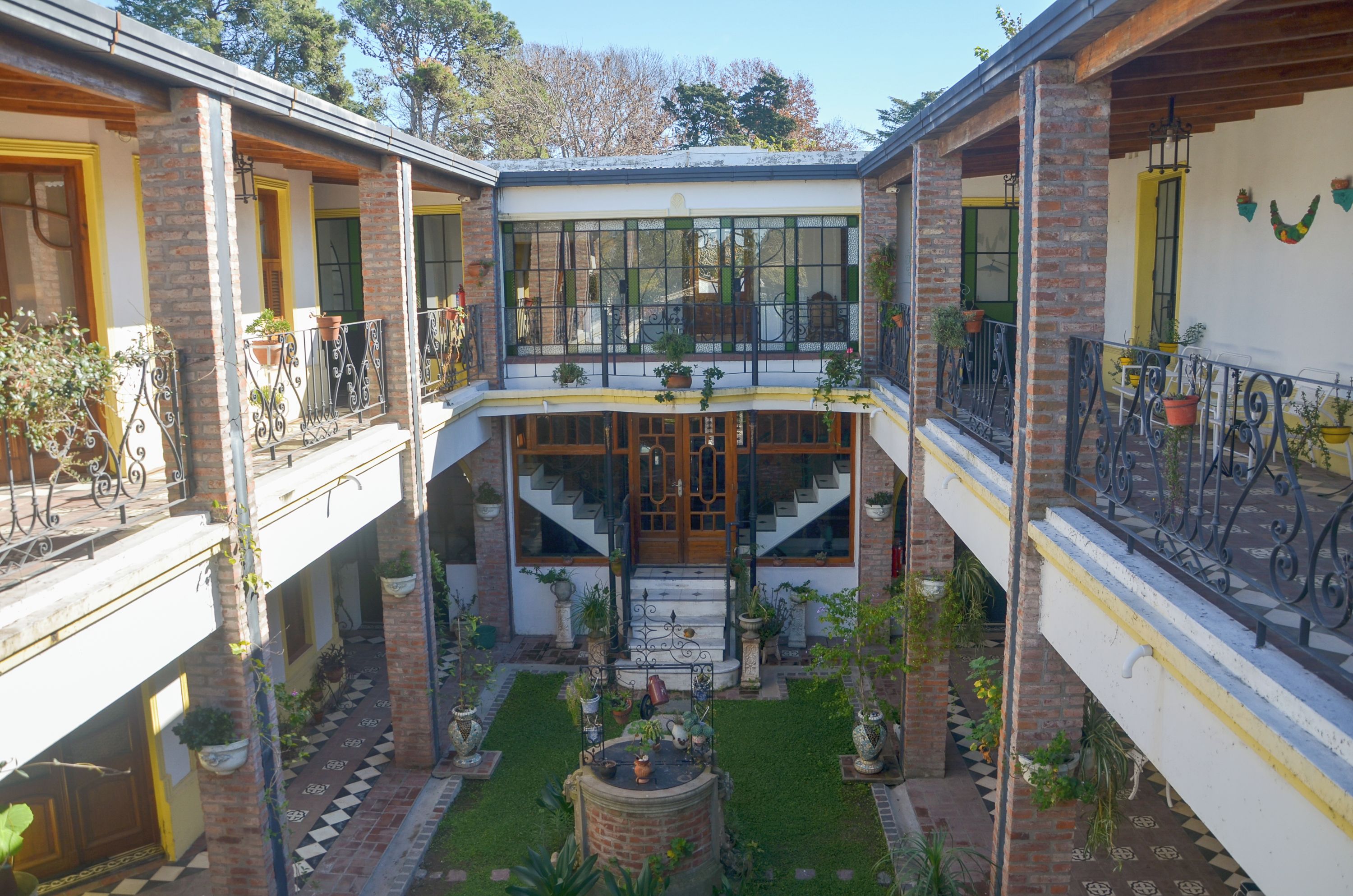Un patio central con una escalera, rodeado de edificios de ladrillo con balcones.