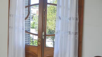 A wooden door with two glass panels, flanked by white curtains with lace trim.